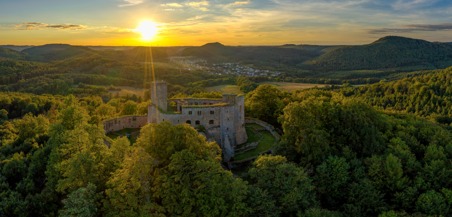 Burg Gräfenstein auf einem Hügel umgeben von dicht bewachsenem Wald und Bergen