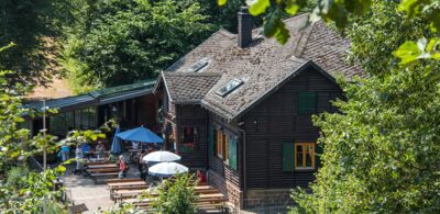 Kohlbachtalhütte inmitten grüner Natur von Resterauntgästen besucht